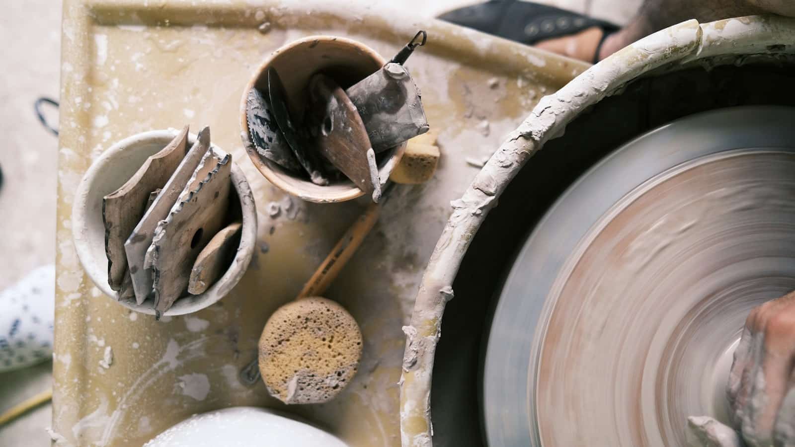 Mãos moldando argila em uma roda de cerâmica