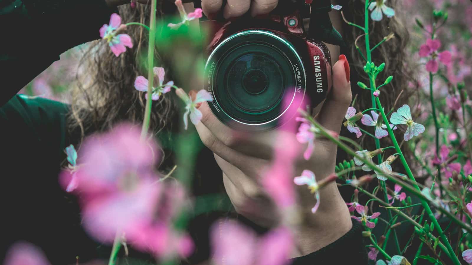 Fotógrafa usando uma câmera para registrar flores
